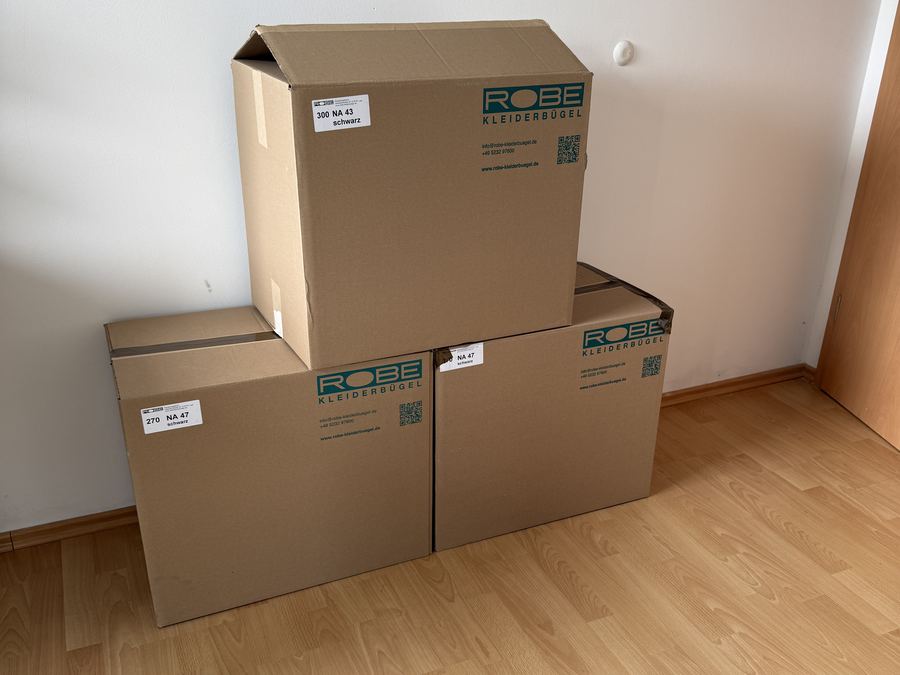 Gestapelte, beschriftete Umzugskartons in einem leeren Zimmer
