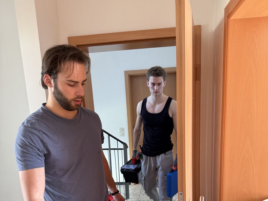 Umzugshelfer mit Werkzeug beim Moebelaufbau in einer Wohnung