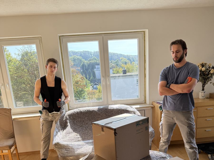 Das Team von Grundstein mit gepackten Kartons und einem verpackten Sessel